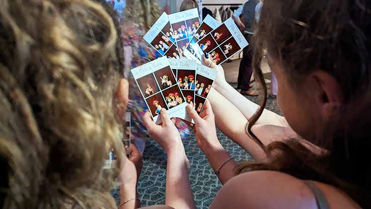 guests looking at photo booth prints